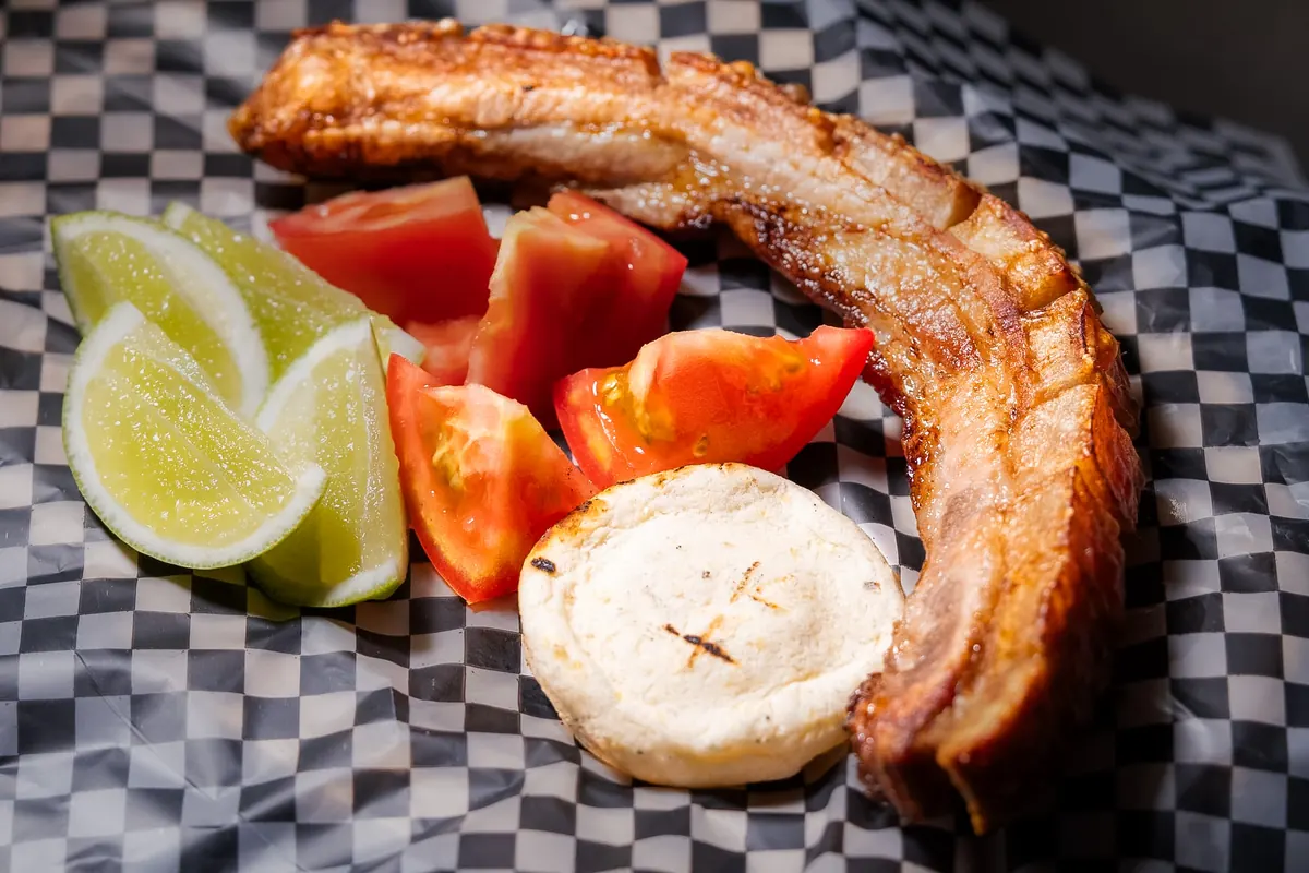 Chicharrón con arepa, tomate y limón